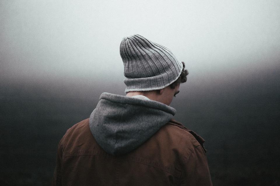Person in a grey beanie and hooded jacket seen from behind